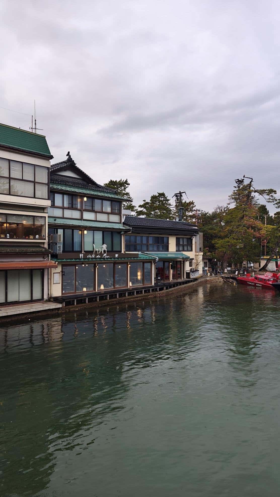 Waterfront buildings with green roofs under cloudy sky