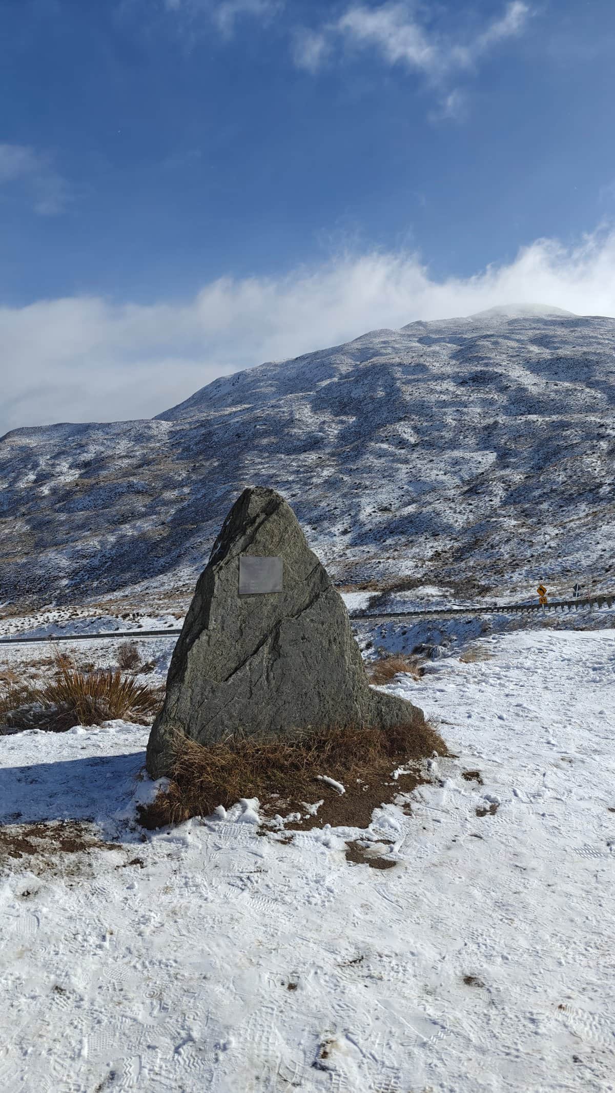 A lower standing-stone marker with a small plaque