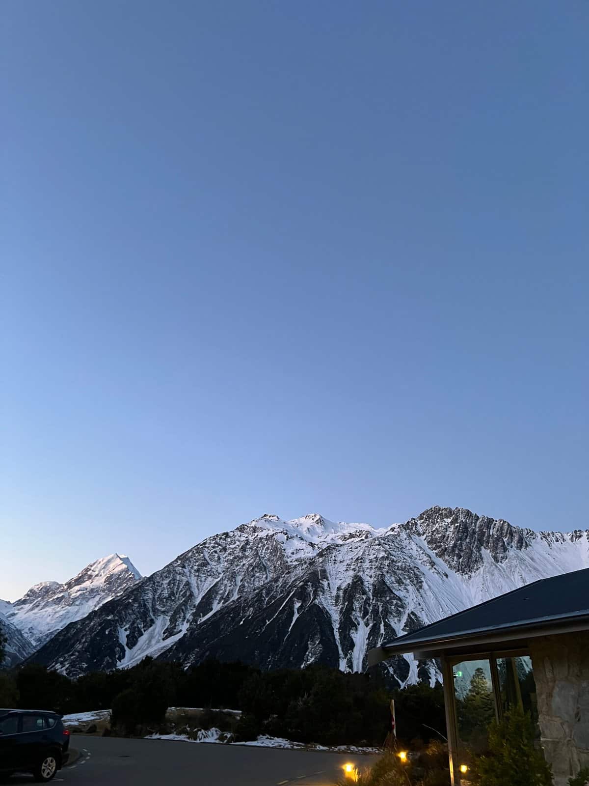 A snowy peak above a building roof and