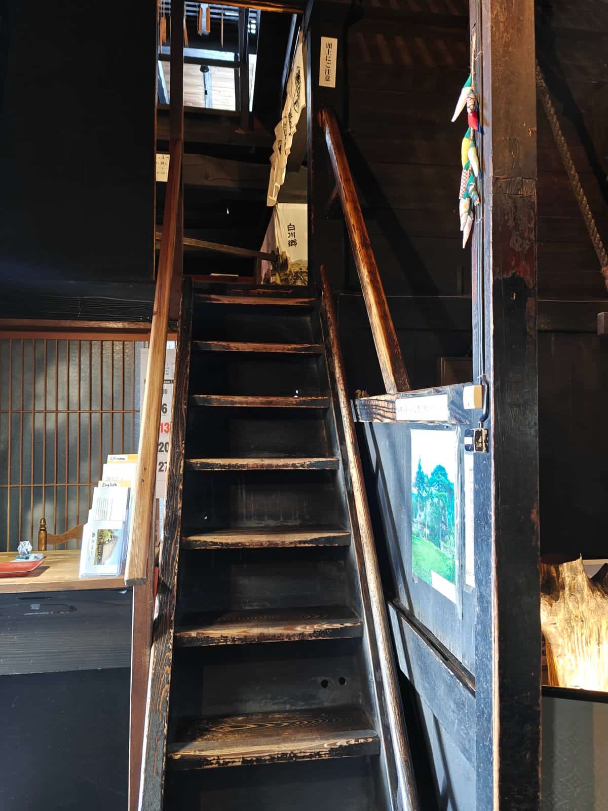 A steep, blackened wooden staircase rising from the