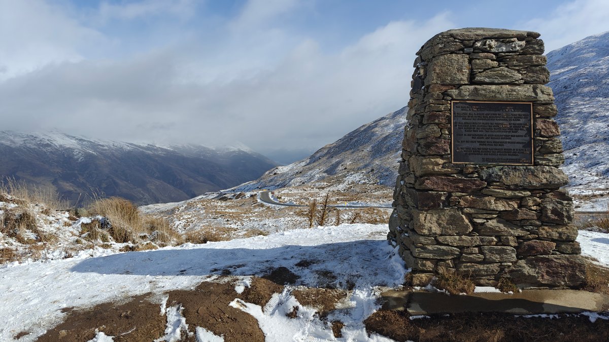 A stone cairn monument standing in the snow