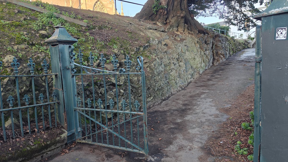 A wrought-iron gate and gravel path running alongside