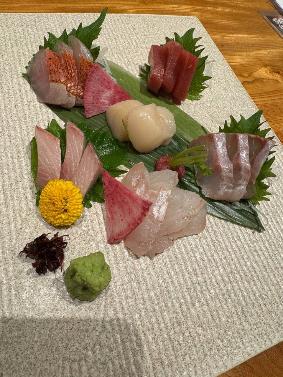 Assorted sashimi platter on a textured square plate: