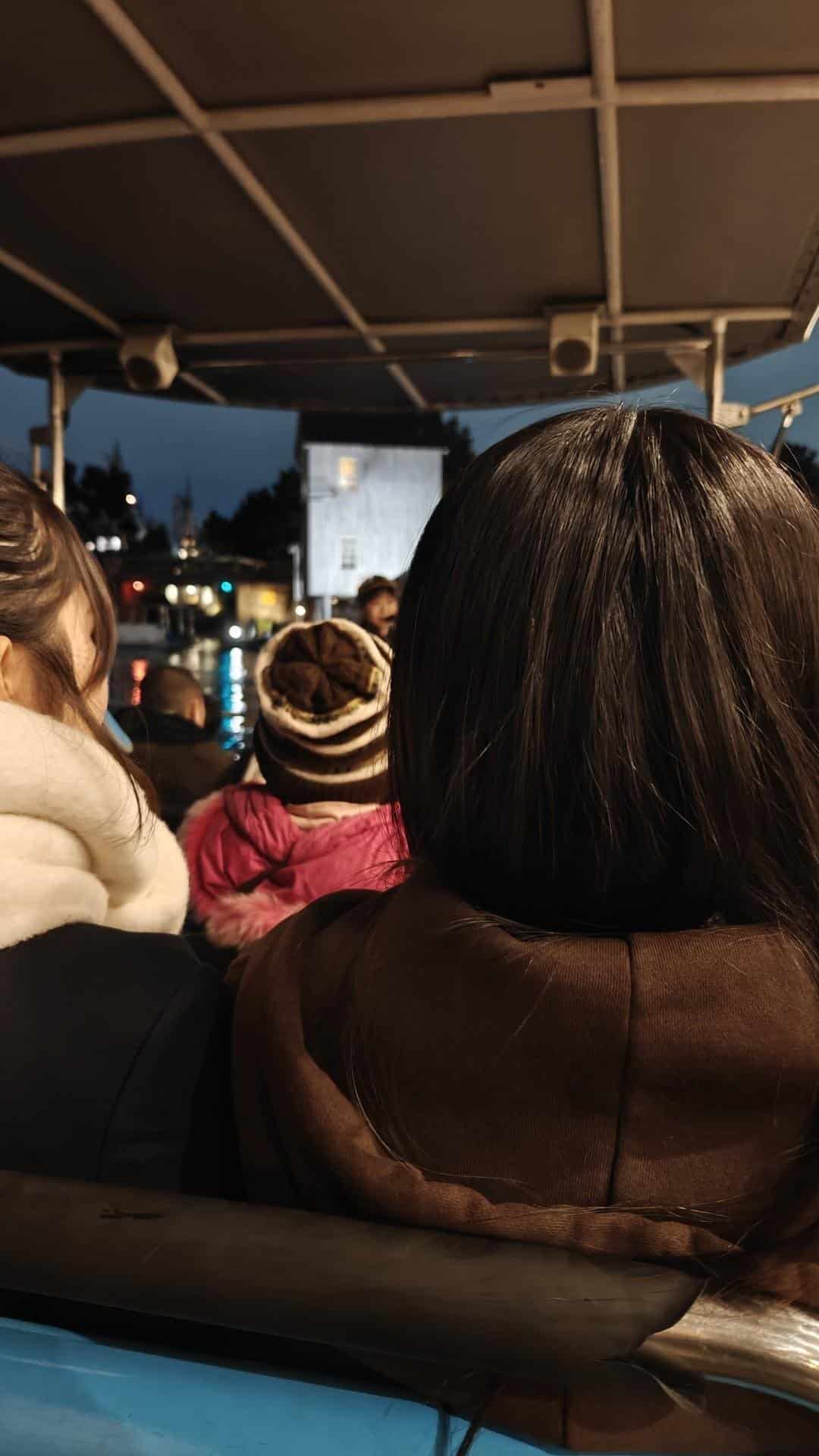Backs of people on evening boat ride