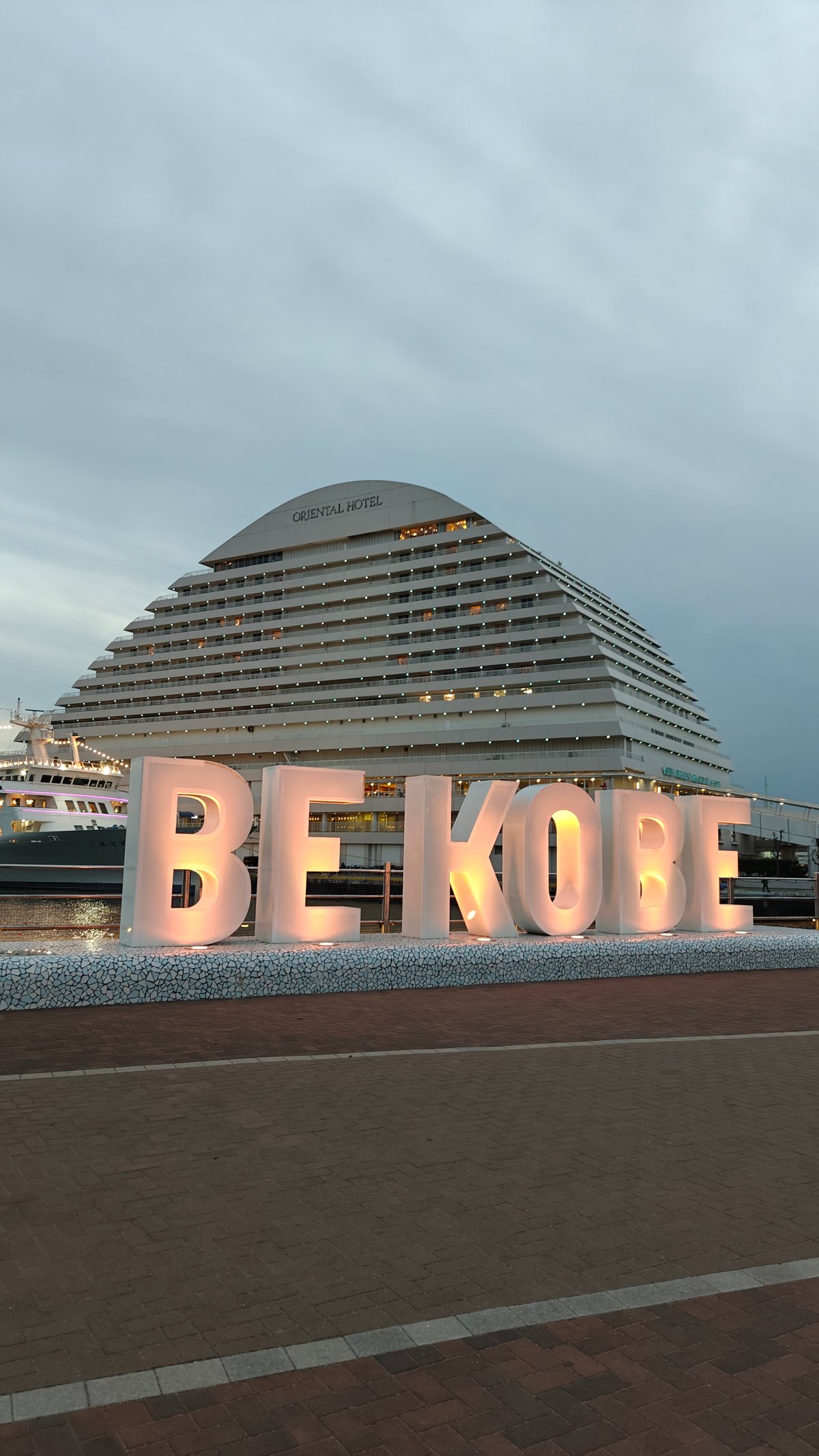 BE KOBE letters with the Oriental Hotel rising