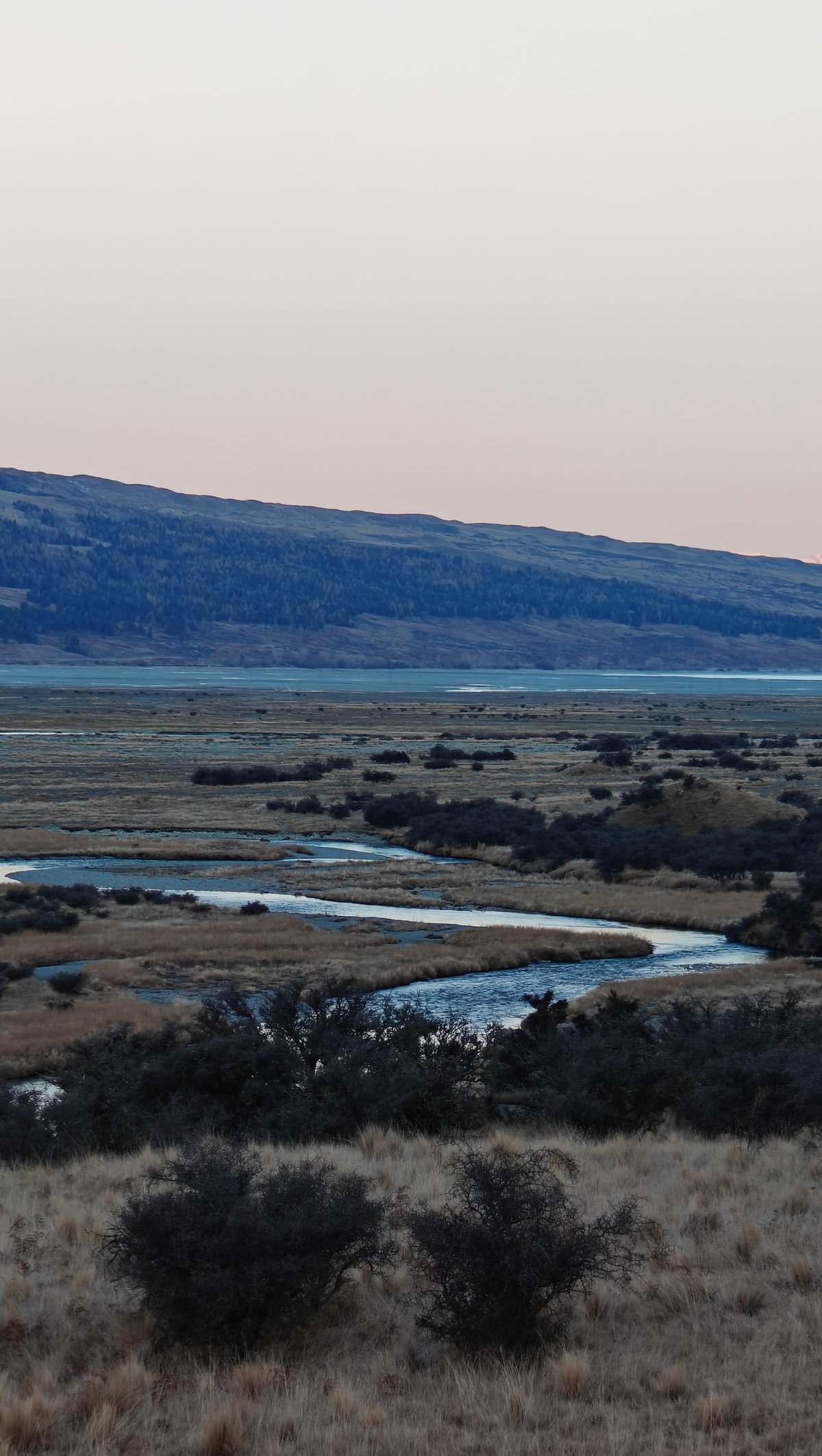 Braided river valley opening toward distant plains and