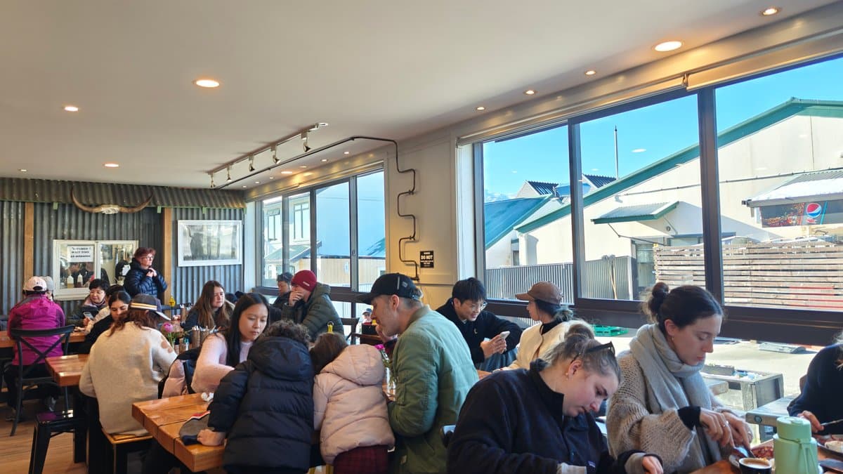 Busy interior of The Greedy Cow cafe: guests