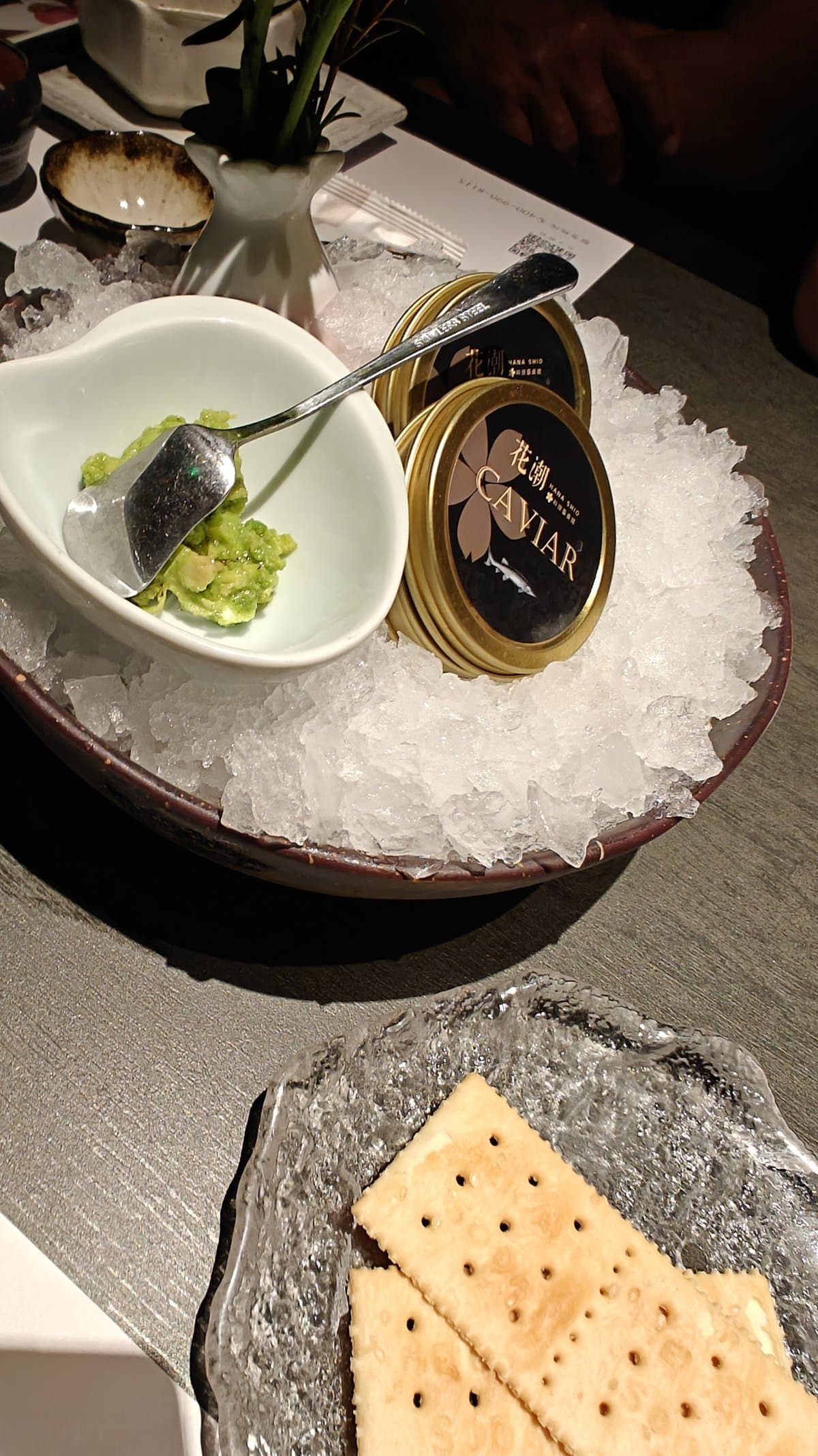 Caviar tin on ice with avocado dip and
