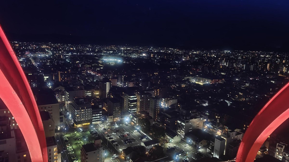 City skyline at night with red arch