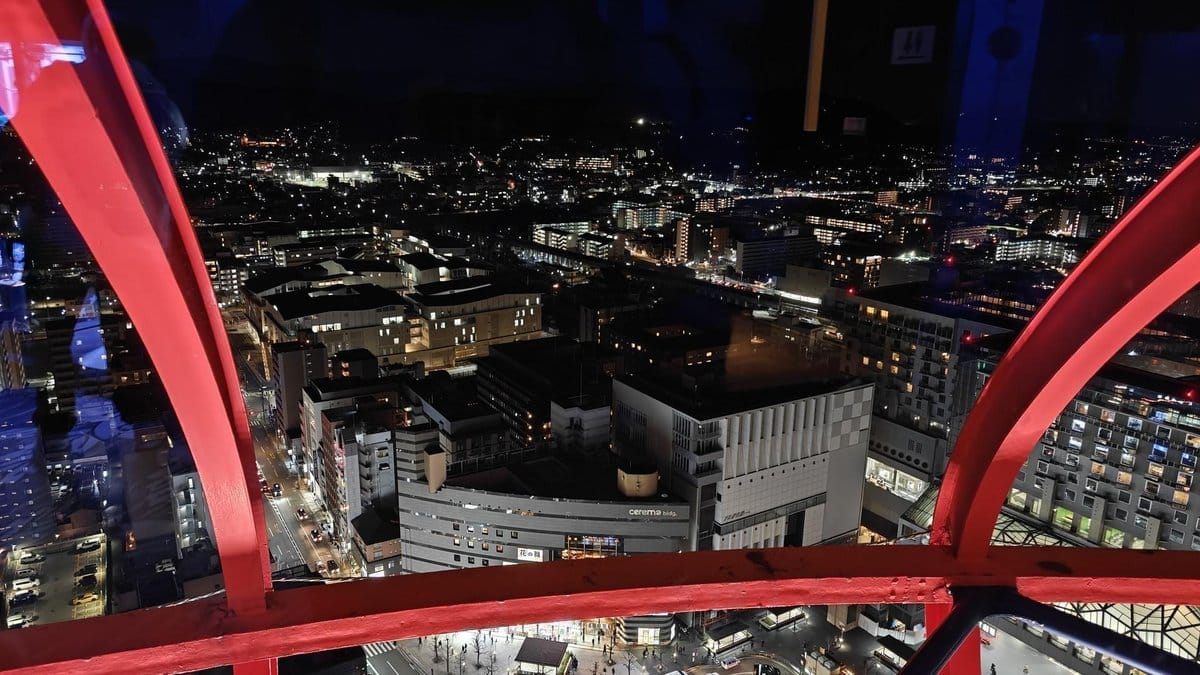 Cityscape view from red-framed window