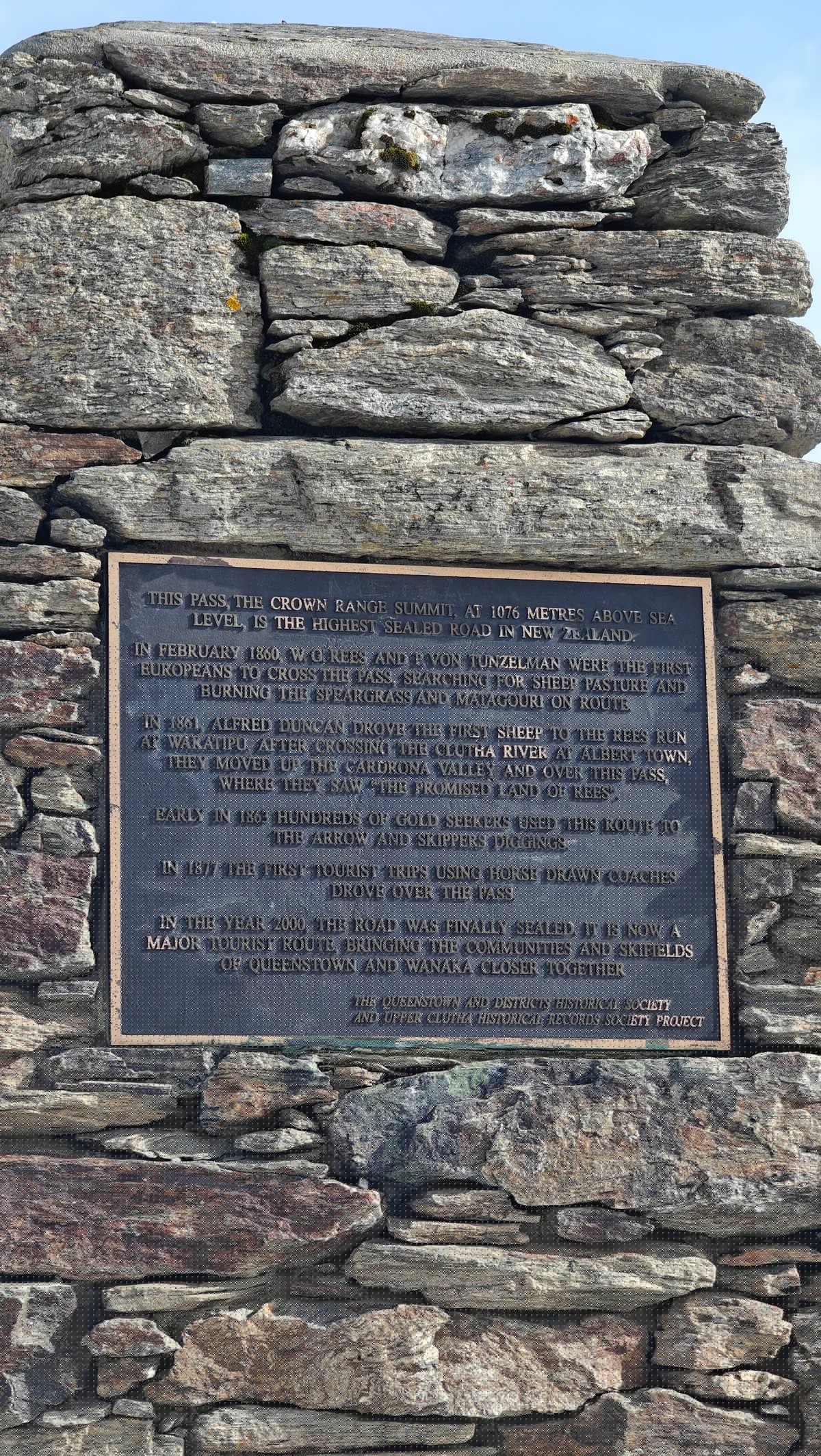 Close-up of the cairn's bronze plaque: 'THIS PASS,