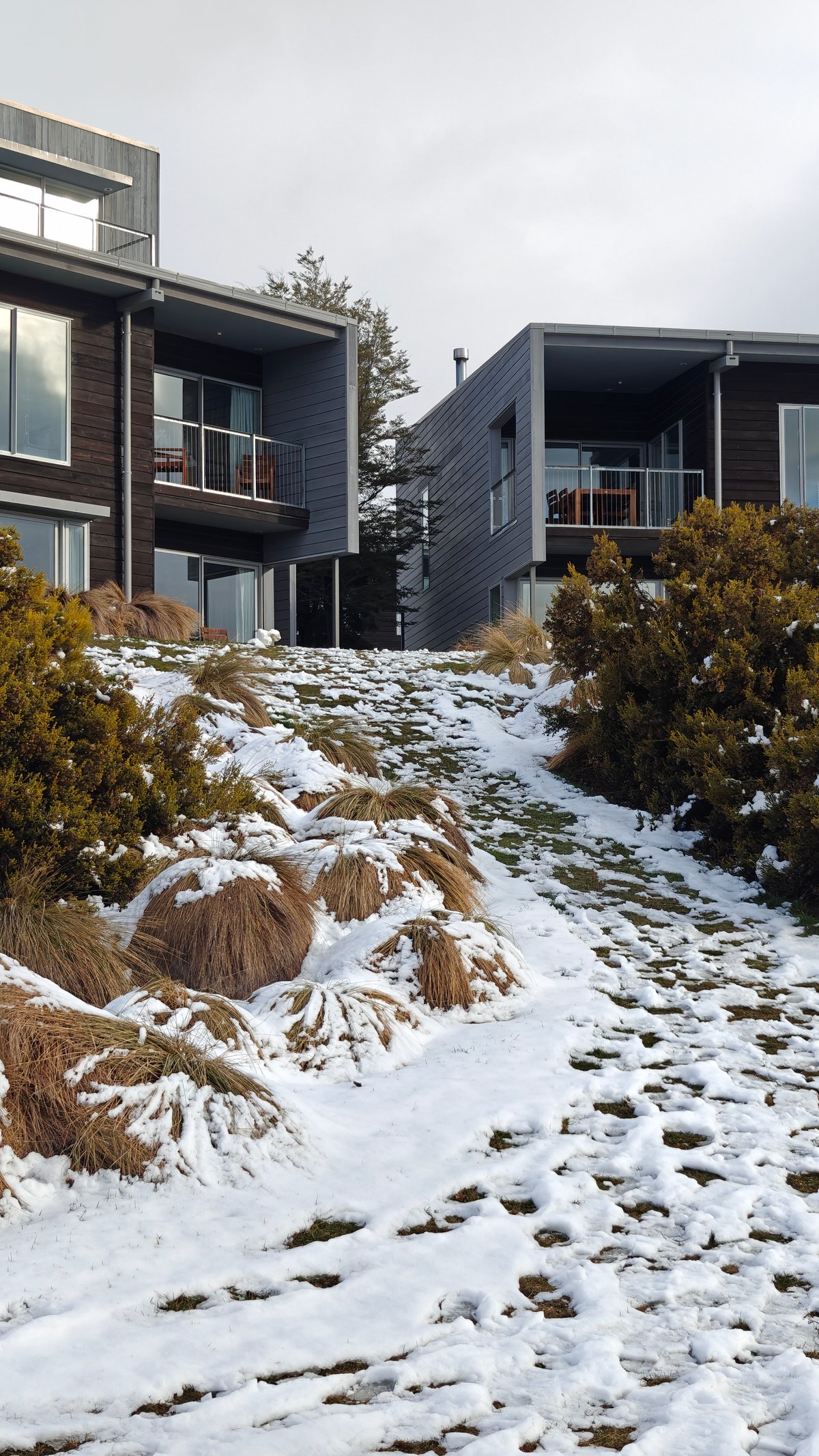 Contemporary dark-clad apartment buildings stepping up the snowy
