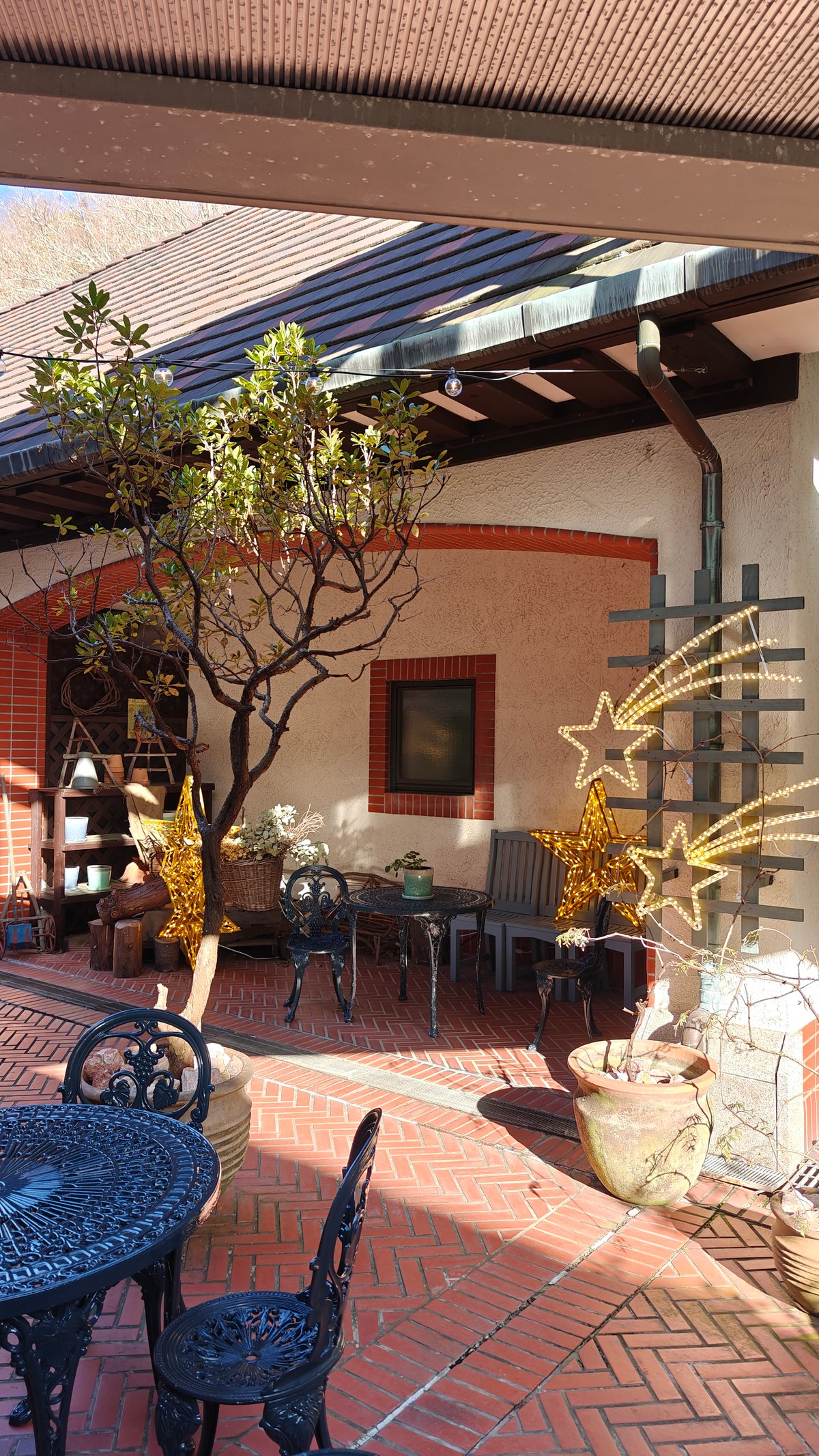 Covered terrace cafe with wrought-iron tables and a