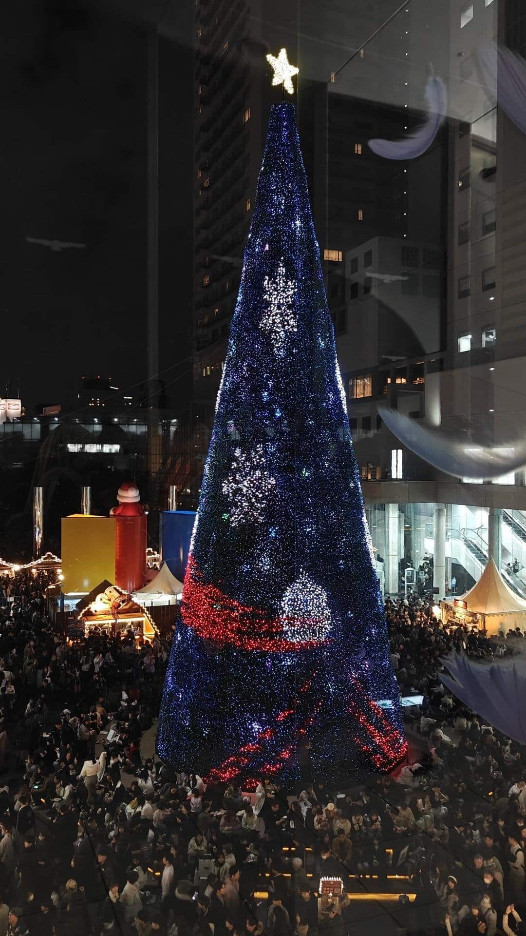 Crowd at festive illuminated Christmas tree