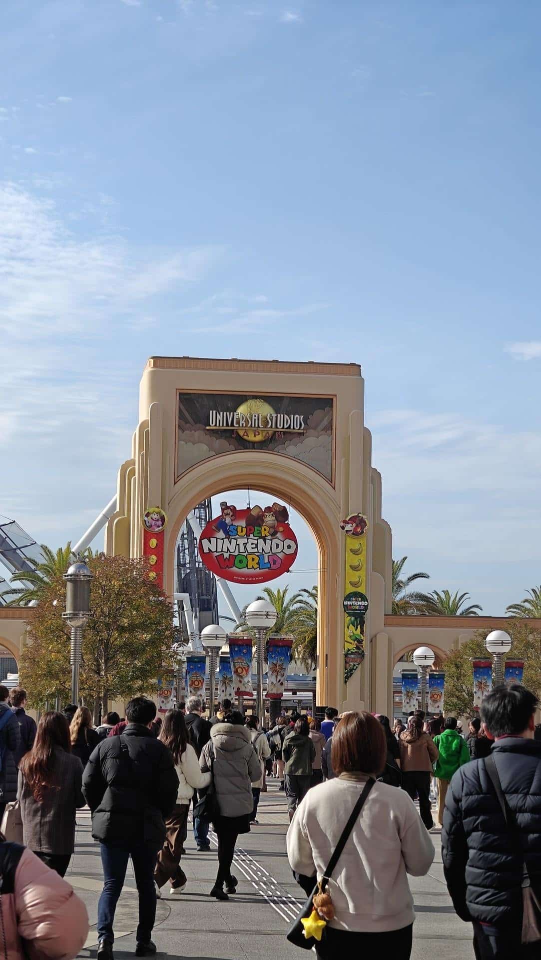 Crowd entering theme park under archway