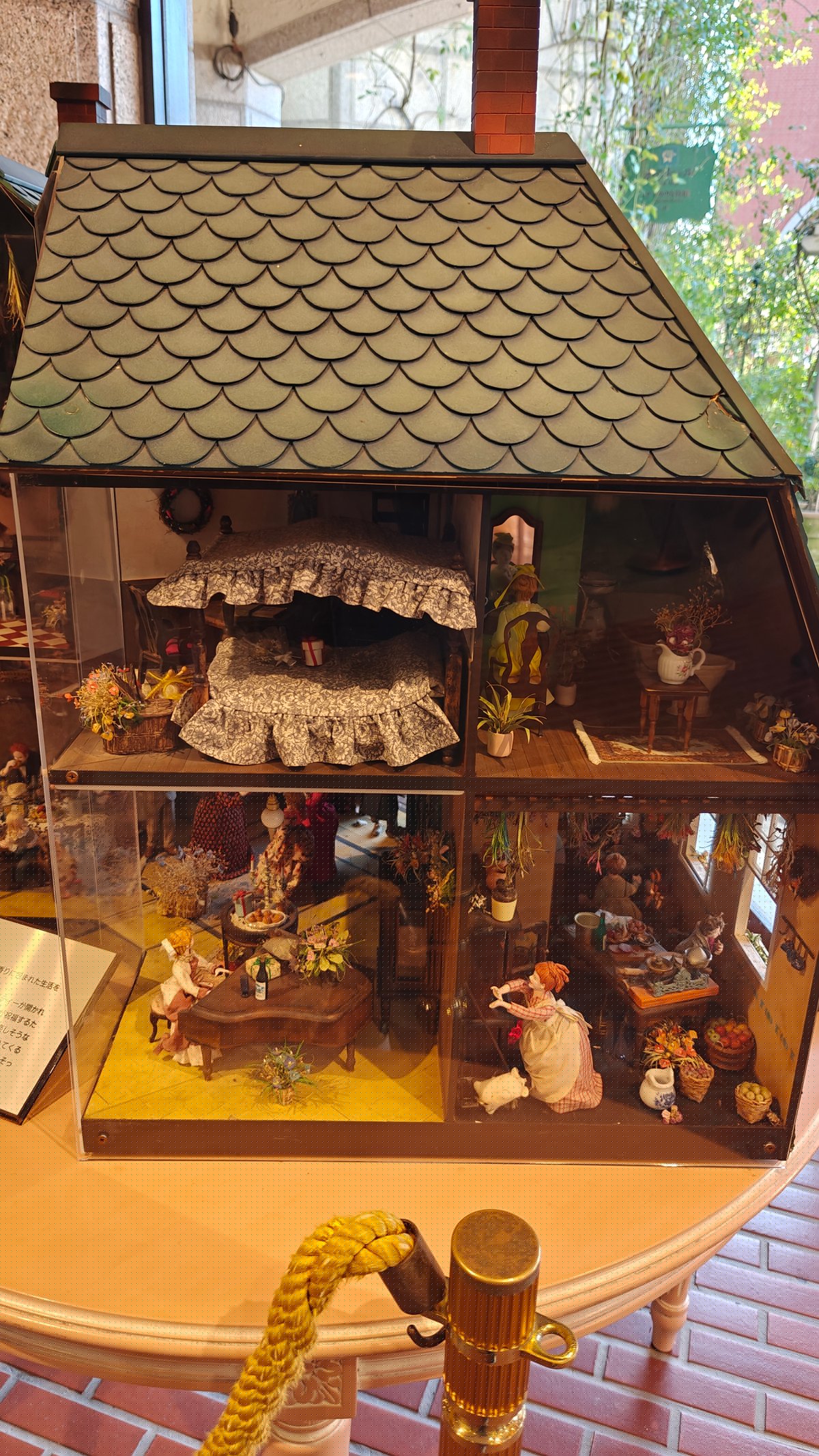 Detailed dollhouse/miniature model displayed in a glass case