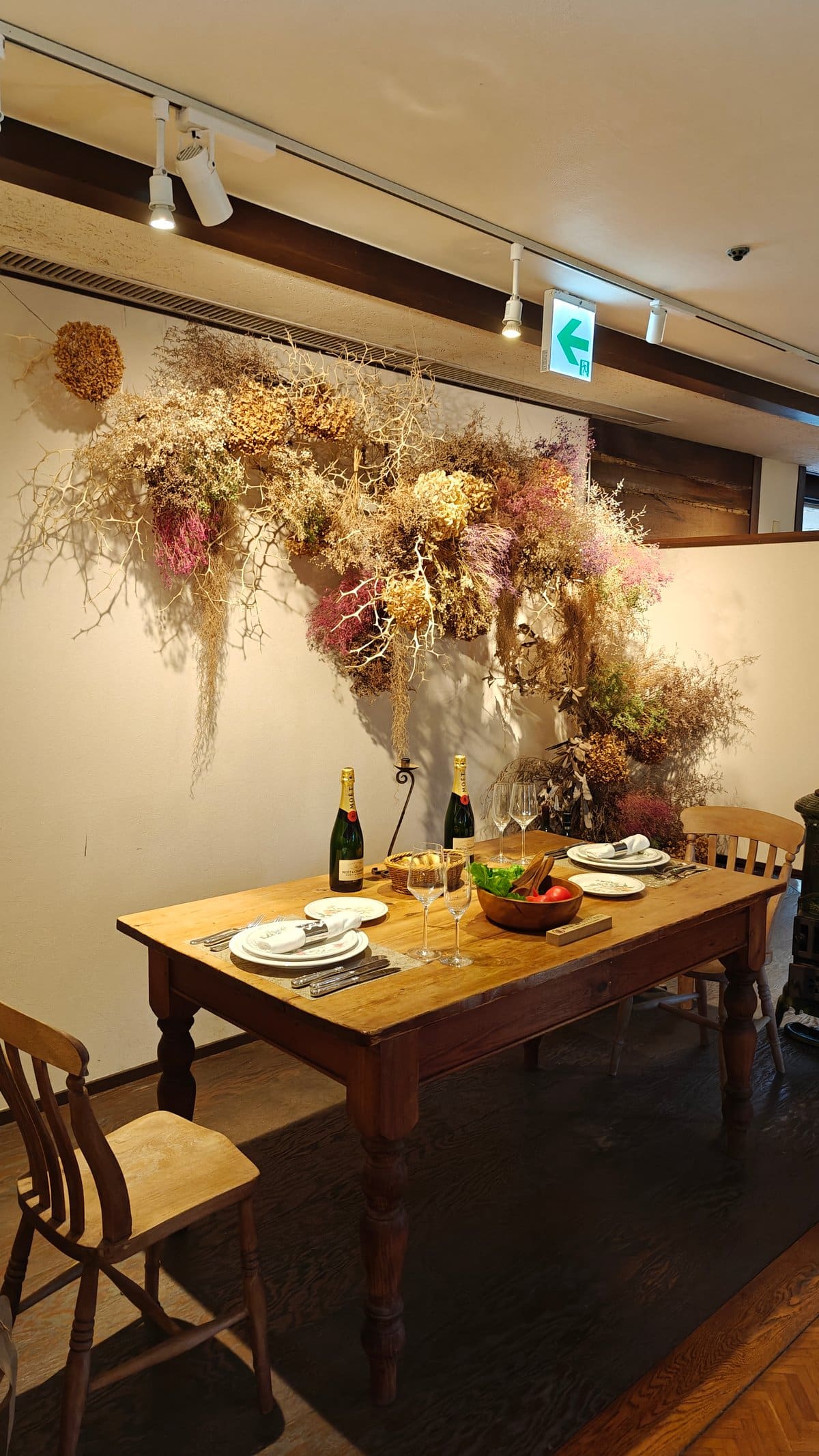 Dining table set with dried-flower arrangement, wine and