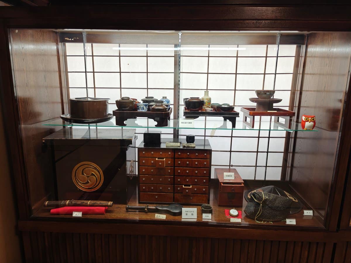 Display case of lacquerware and household items, including