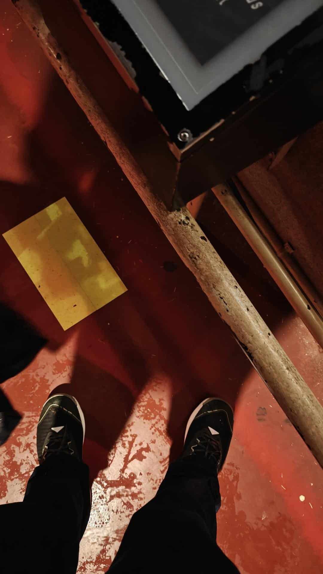 Feet on red floor with wooden beam