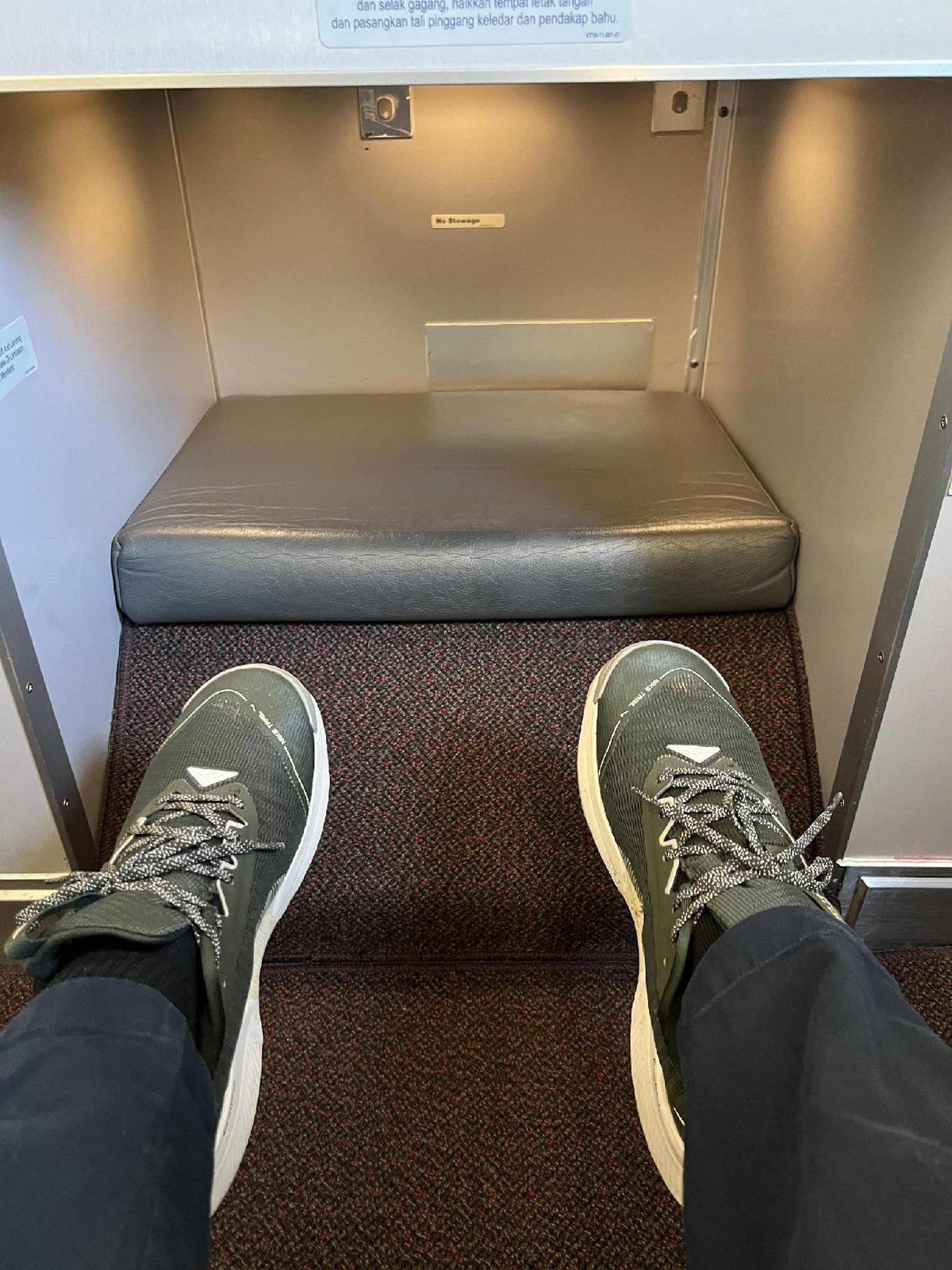 Feet resting on airplane footrest