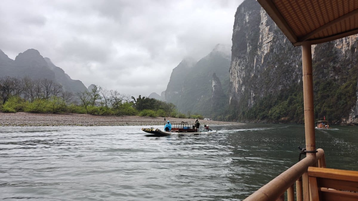 Fisherman raft amid rainy peaks