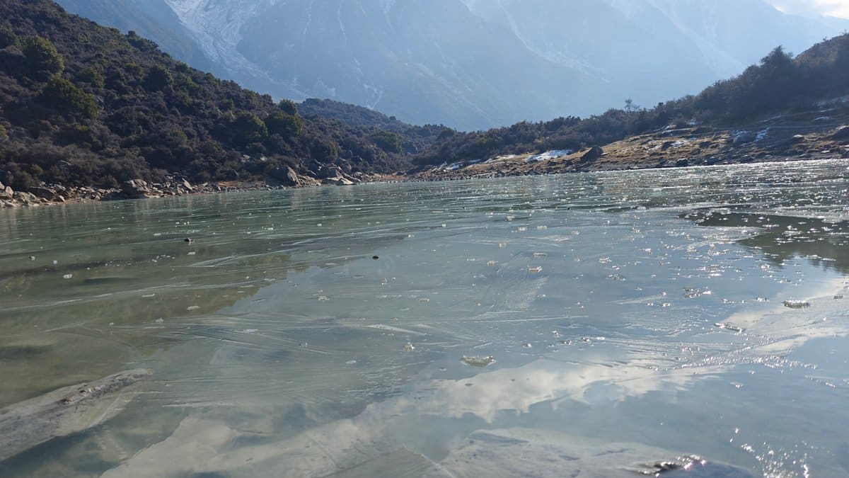 Frozen lake mirrors mountains
