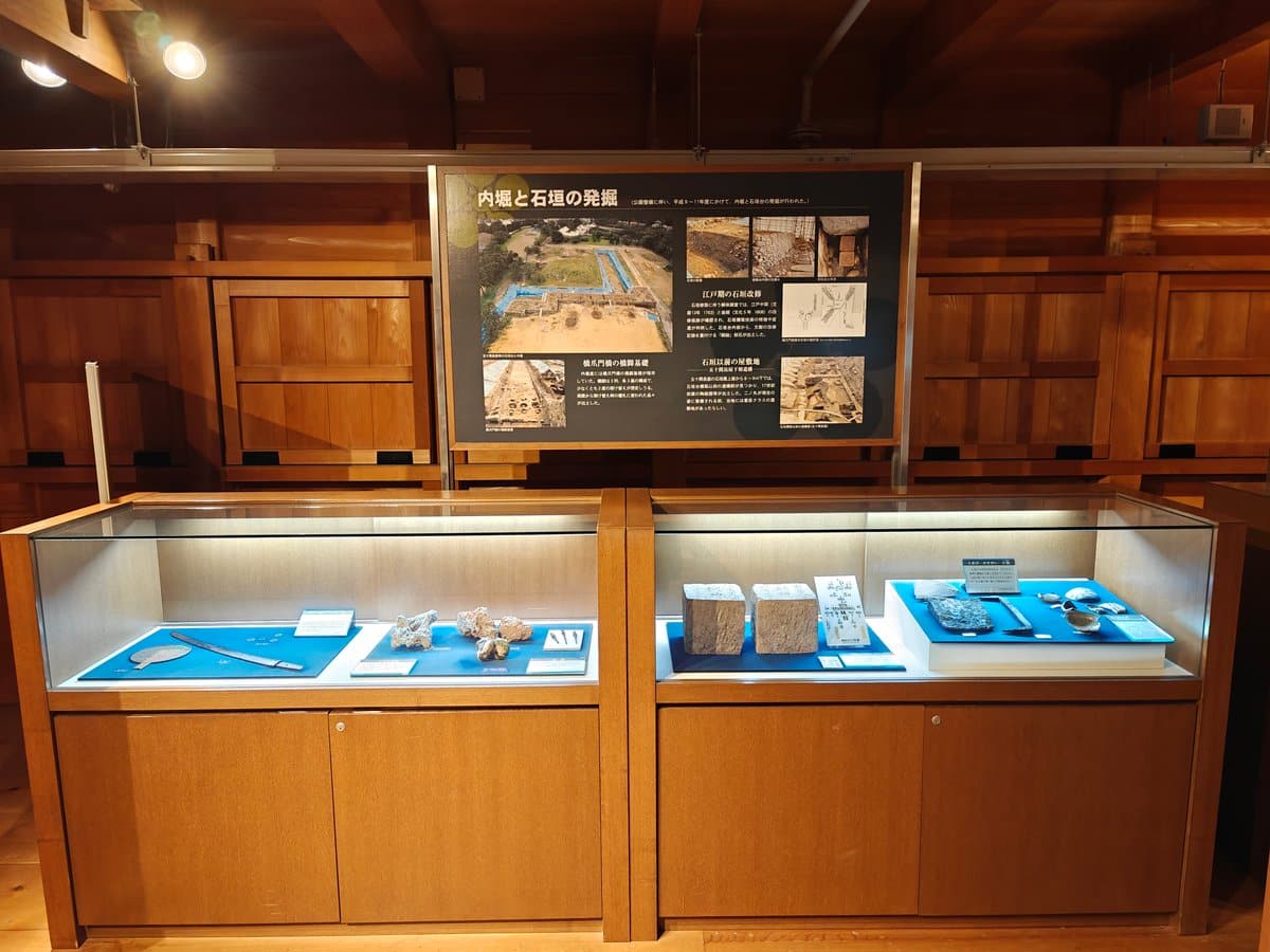 Glass display case of excavated stone blocks, iron