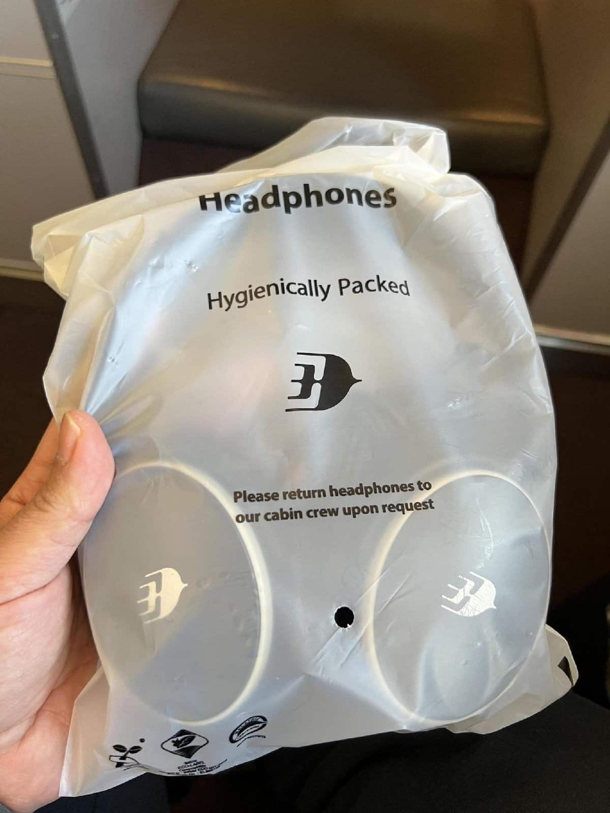 Hand holding packaged headphones