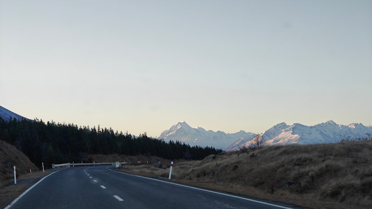 Highway curving through dry hills at dusk, a