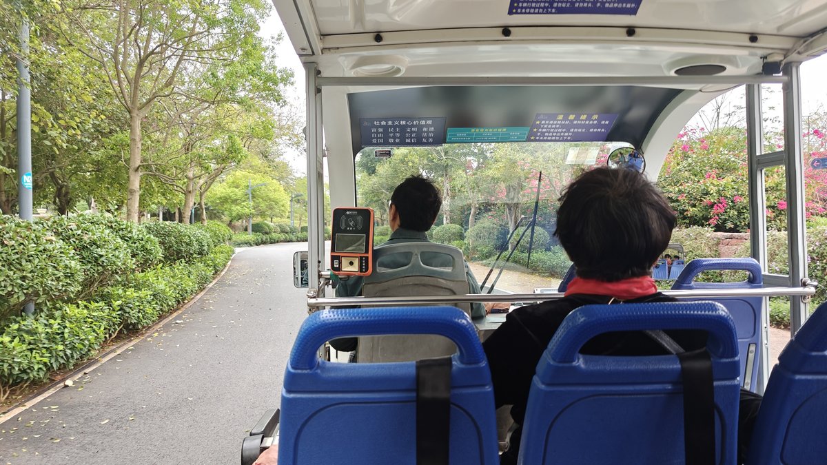 Inside electric sightseeing cart, driver and passenger ahead,