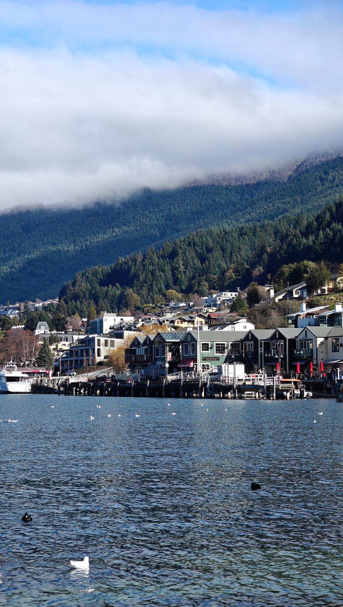 Lakefront town houses and jetties beneath a mountain