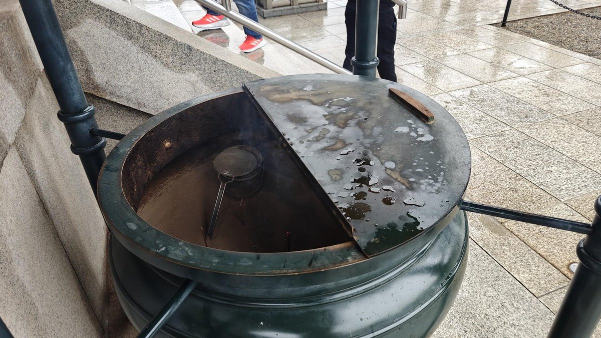 Large incense burner on wet pavement