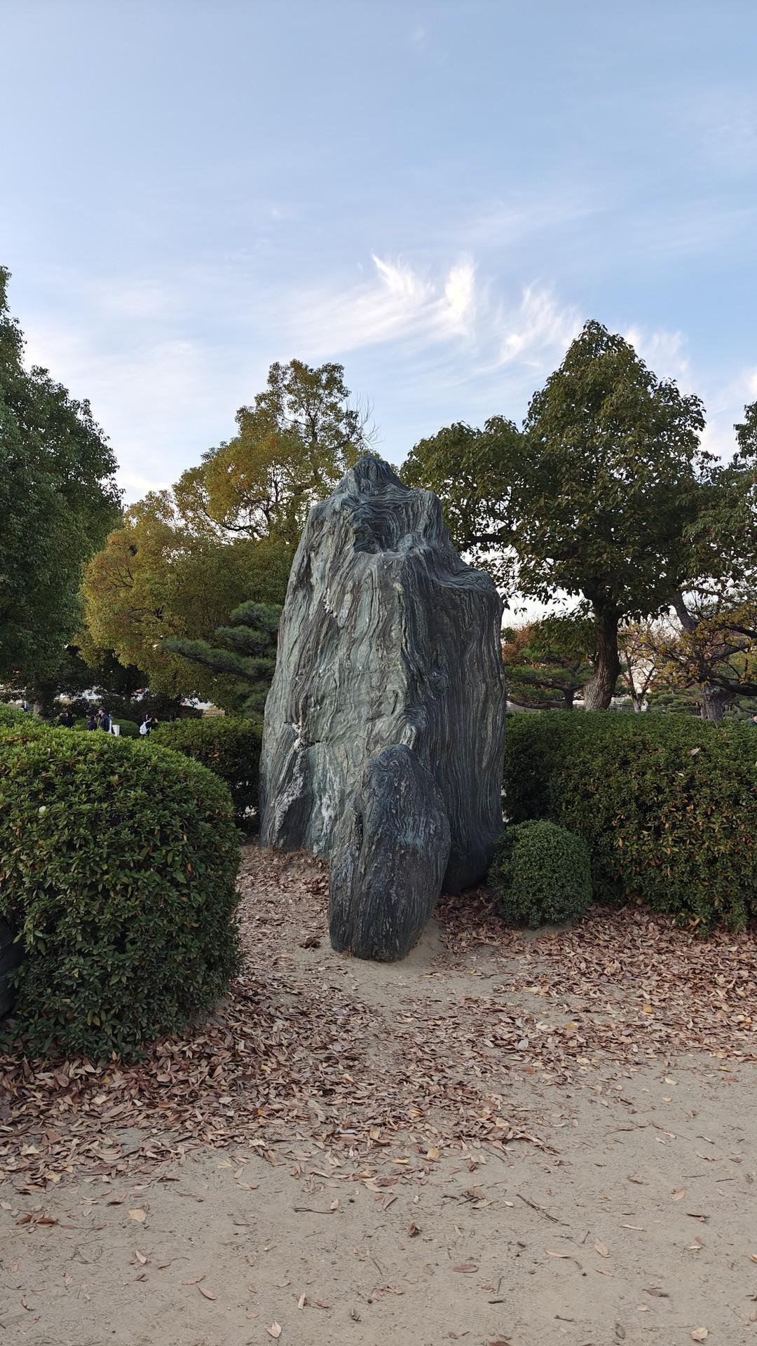 Large rock among green trees