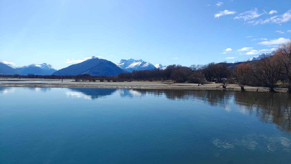 Mirror-calm lake reflecting surrounding mountains