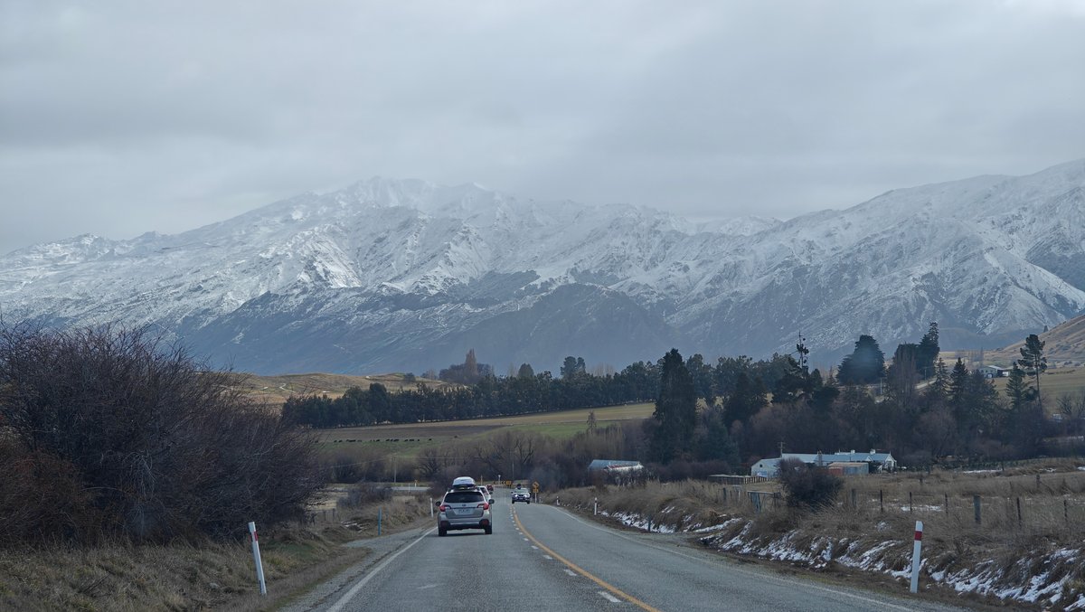 Open road to layered snow peaks
