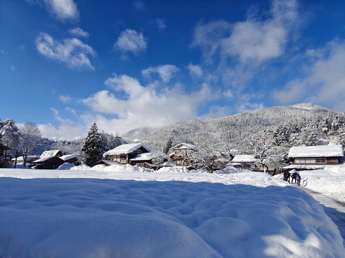 Open snowfield with distant houses
