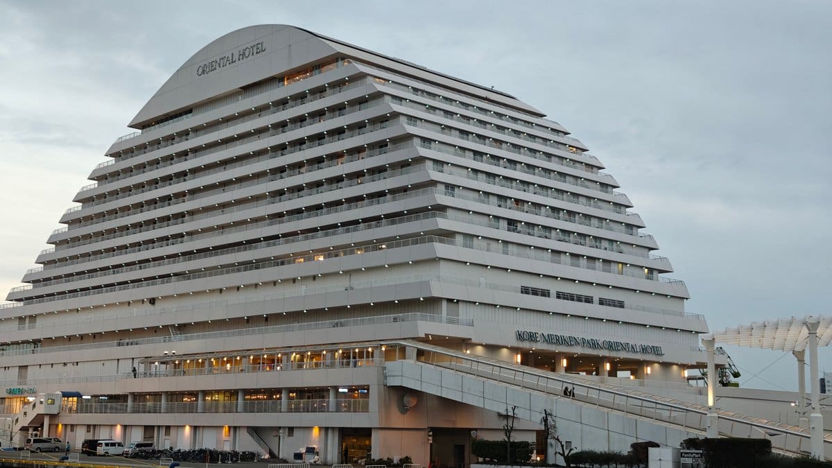 Oriental Hotel front-on, its curved white roof carrying