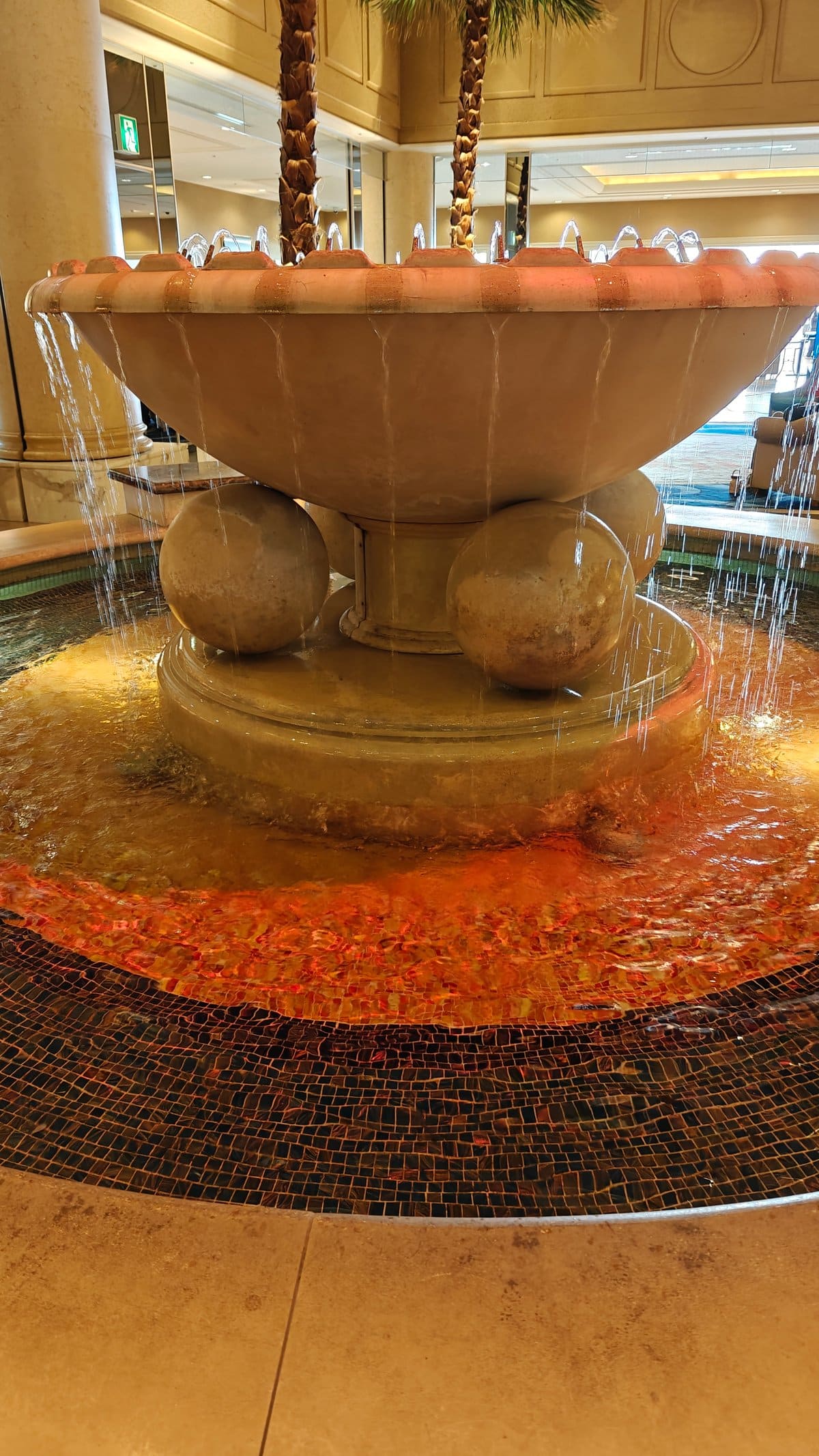 Ornate tiered stone lobby fountain with water cascading