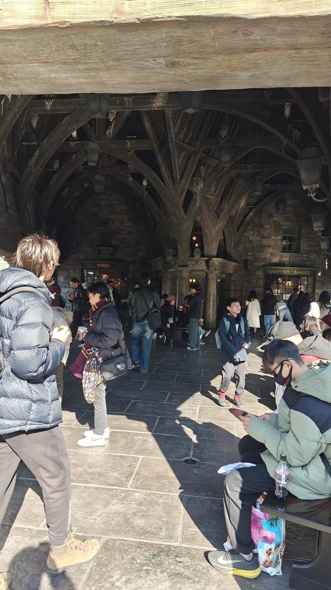 People under stone archway in sunlight