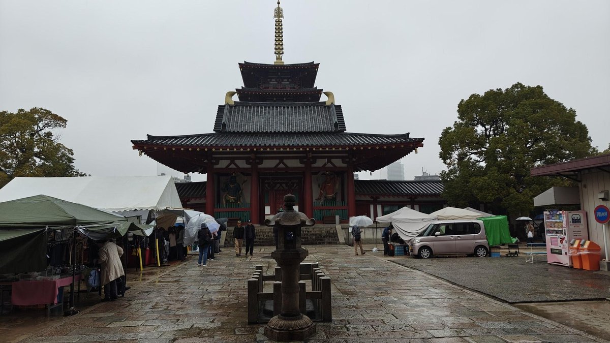 People with umbrellas at temple market