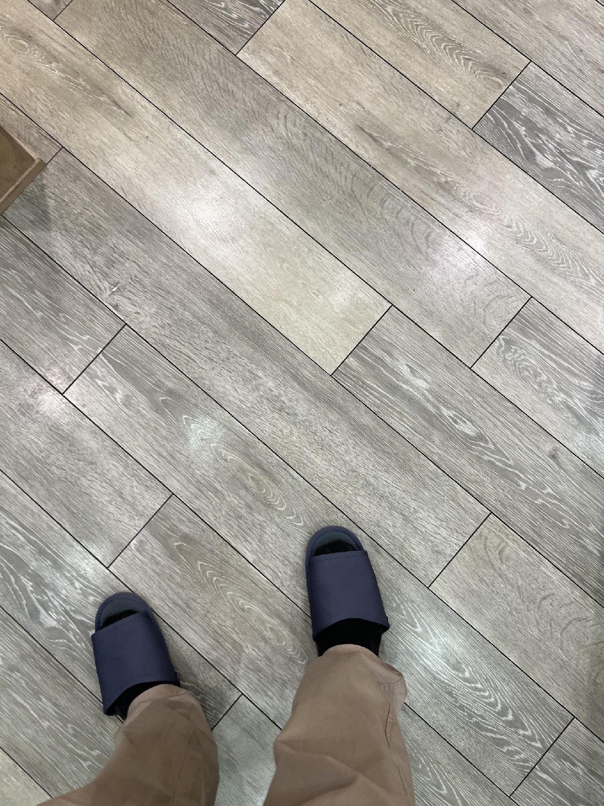Person in blue slides on wooden floor