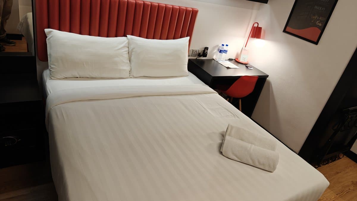 Red headboard bed with towels