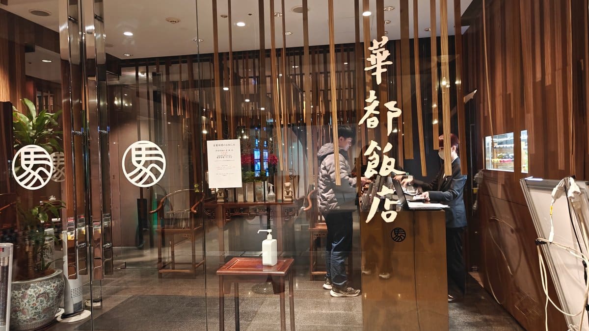 Restaurant exterior entrance with gold '華都飯店' signage on