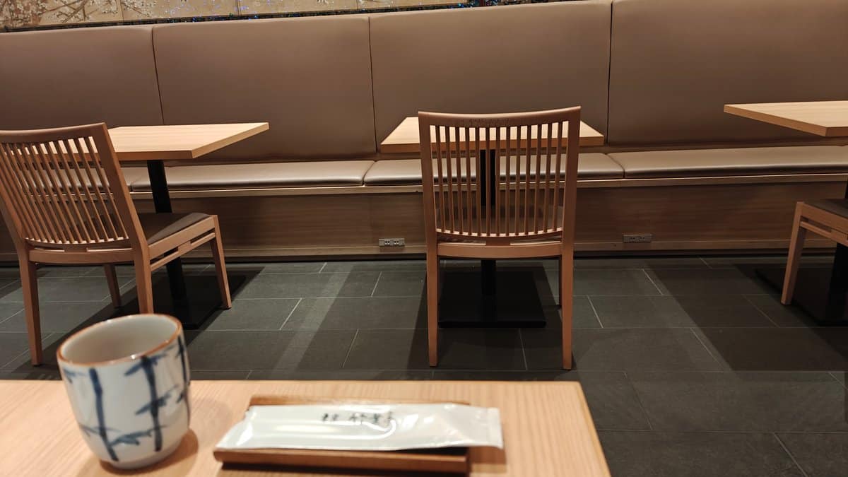 Restaurant interior with clean wooden tables, cushioned bench