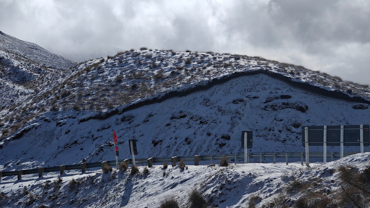 Snow-blanketed mountain slope with a low modern building