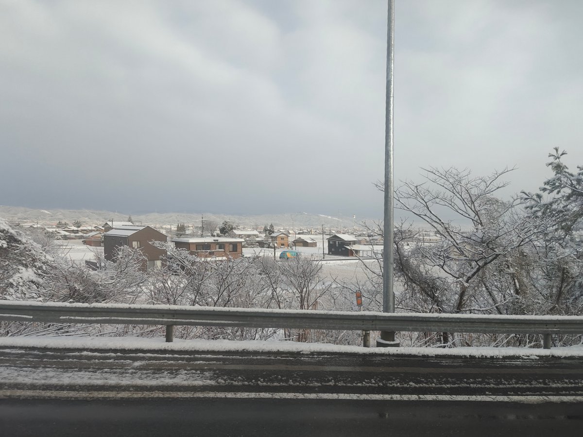 Snow-covered farm fields and a distant hillside seen