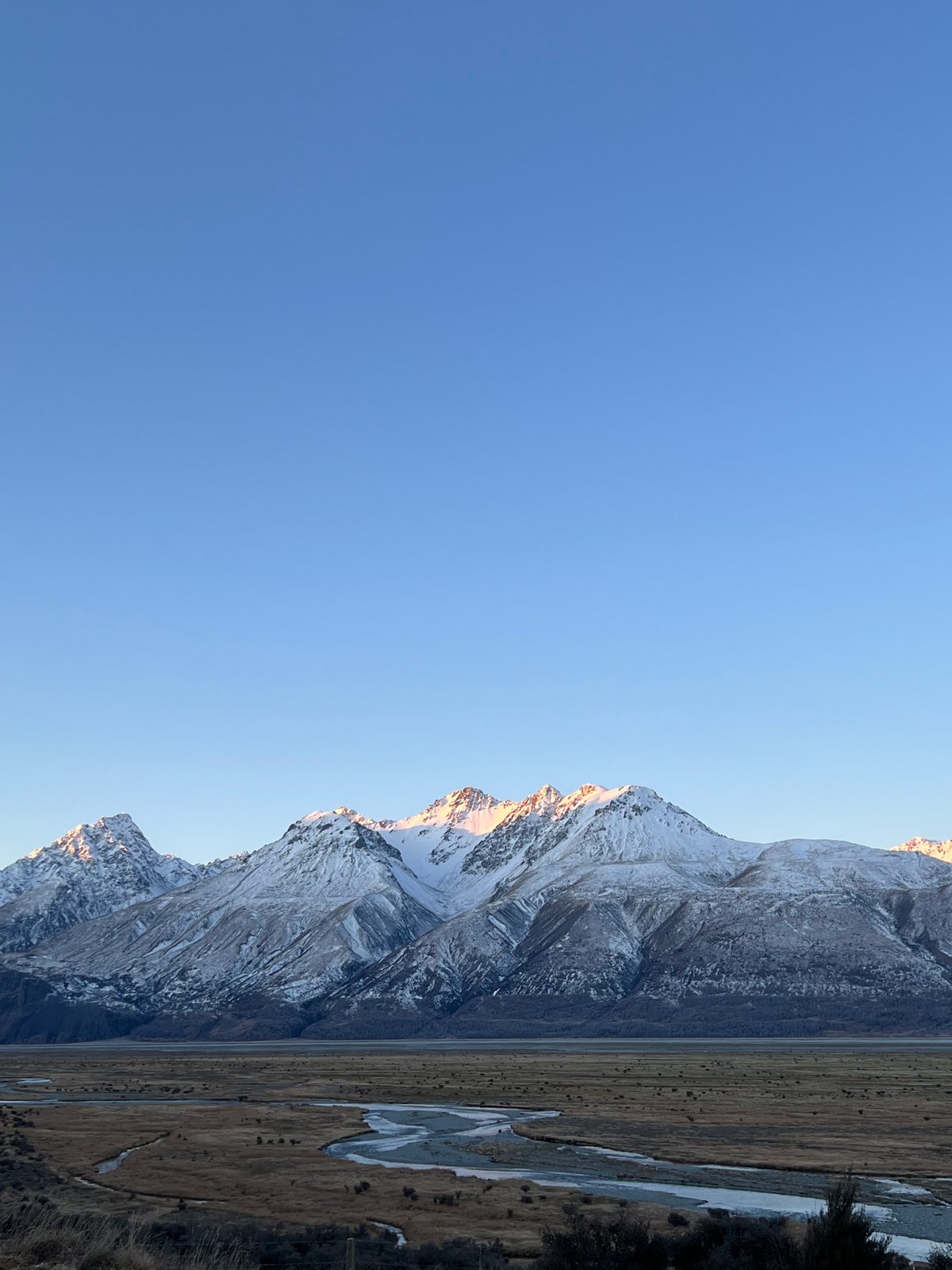 Snow-covered mountains and the braided river at dawn