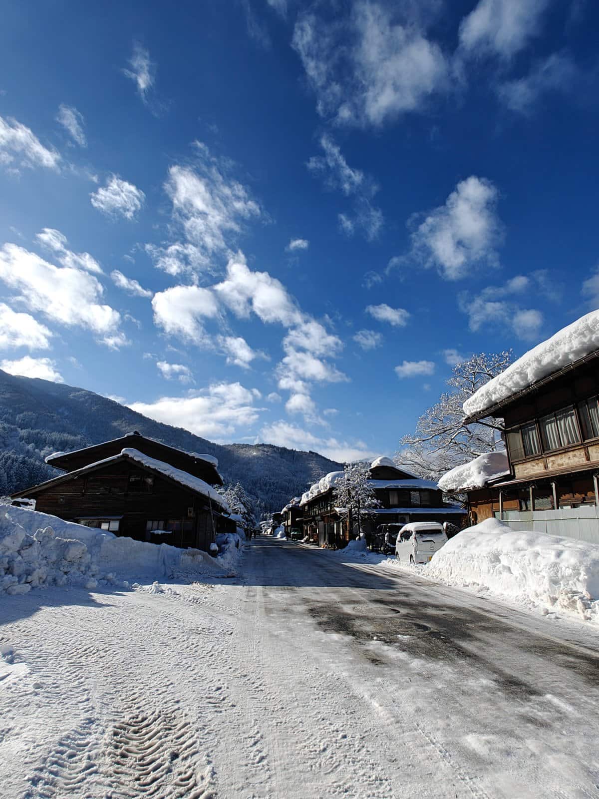 Snow-lined street under blue sky