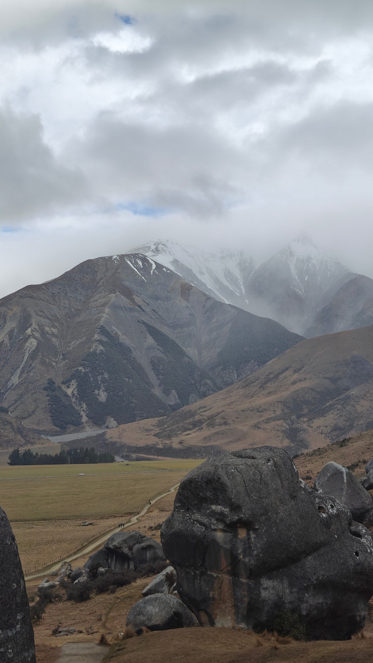 Snow range beyond boulders