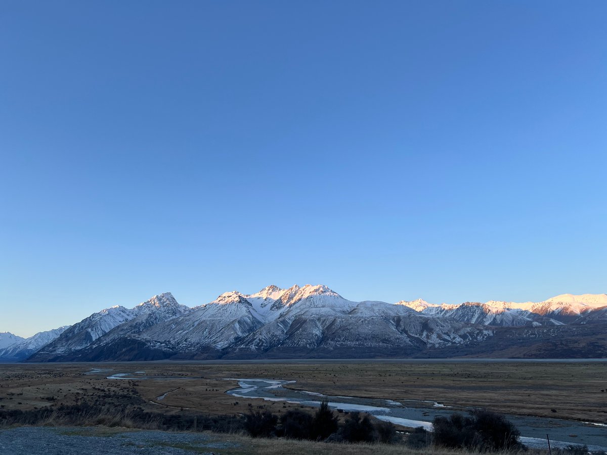 Snow-streaked range over river flats